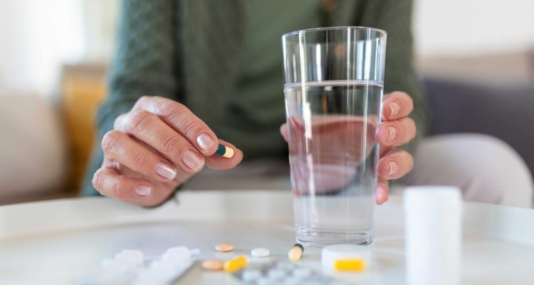 jpeg-optimizer_senior-woman-takes-pill-with-glass-water-hand-1536x1024