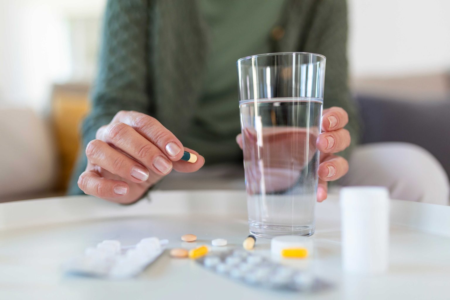 jpeg-optimizer_senior-woman-takes-pill-with-glass-water-hand-1536x1024