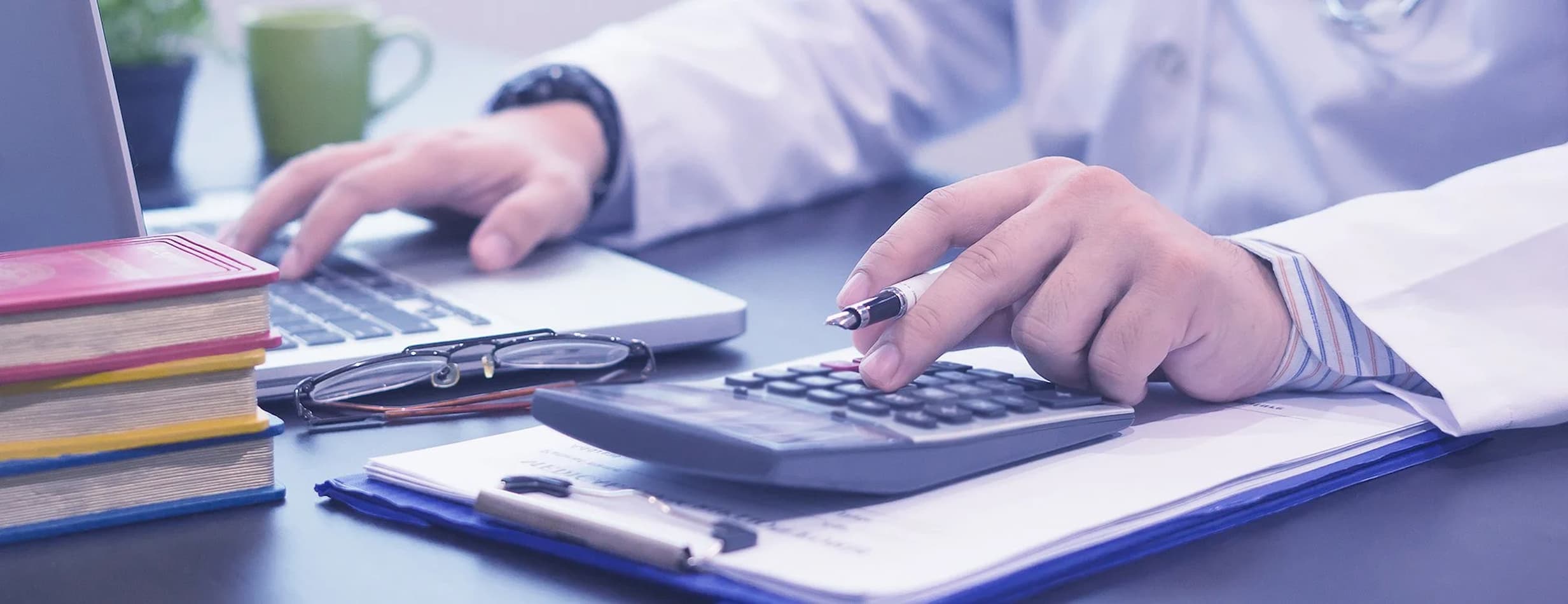 doctor-at-desk-with-calculator-ultrawide