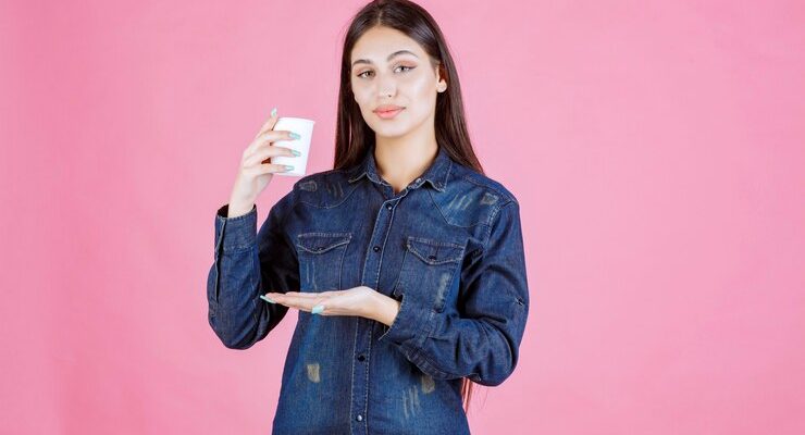 girl-denim-shirt-holding-coffee-cup-feels-positive_144627-55329