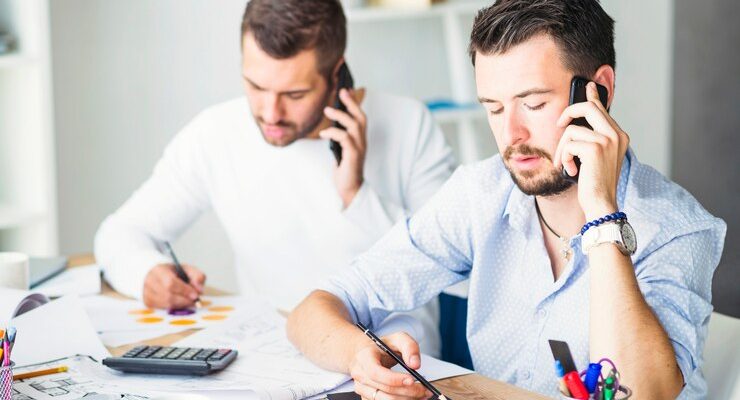 two-businessmen-talking-cellphone_23-2147839911