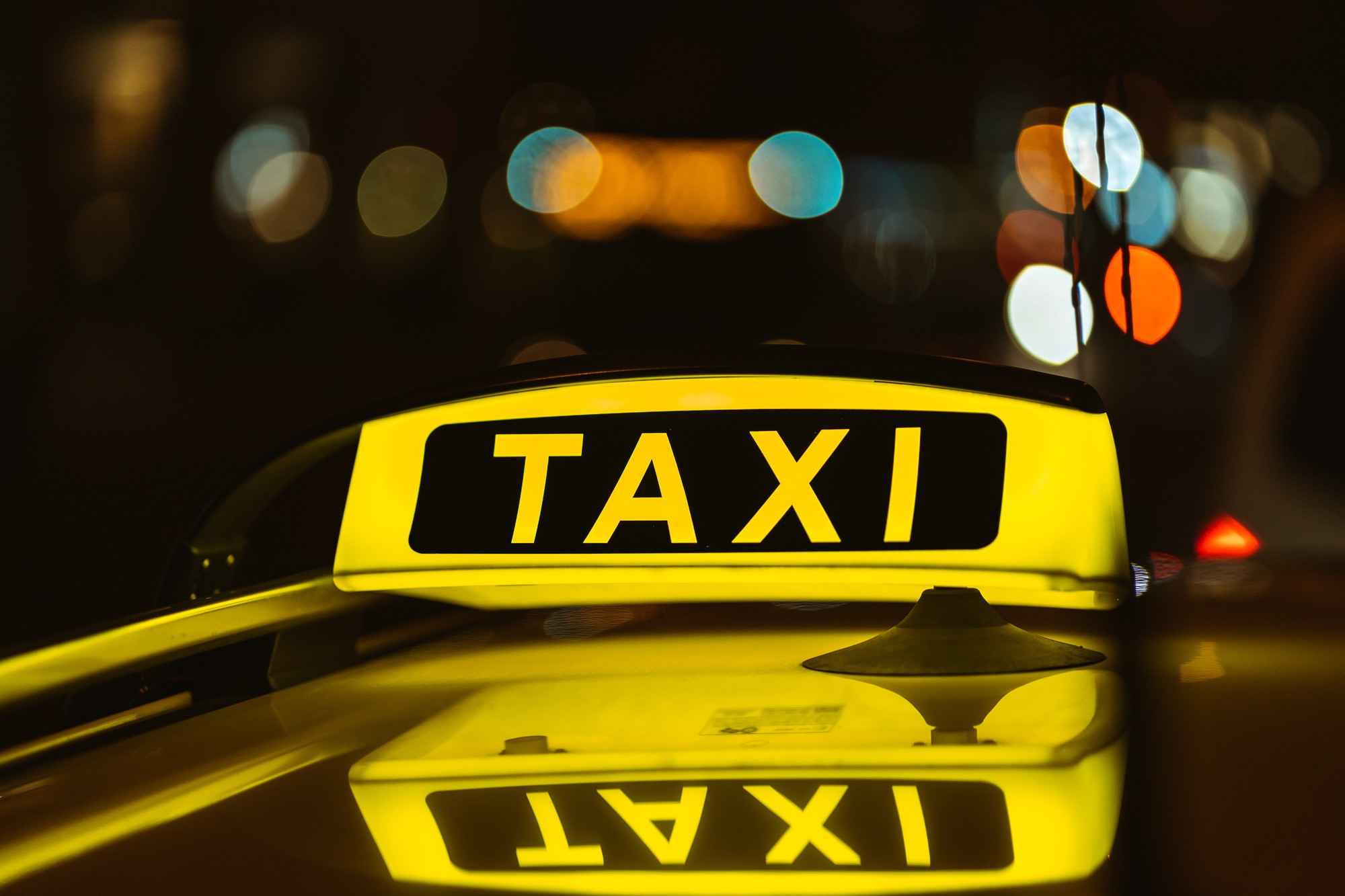 black-yellow-sign-taxi-night-placed-top-car_11zon