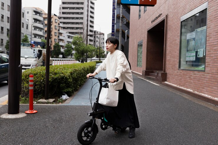 woman-using-electric-bicycle-city_23-2149026652